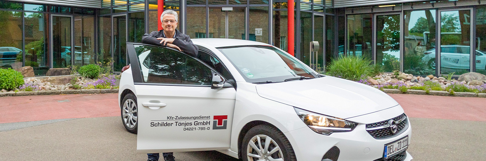 Fahrzeug mit Mitarbeiter vor Zentrale der Tönjes Holding AG