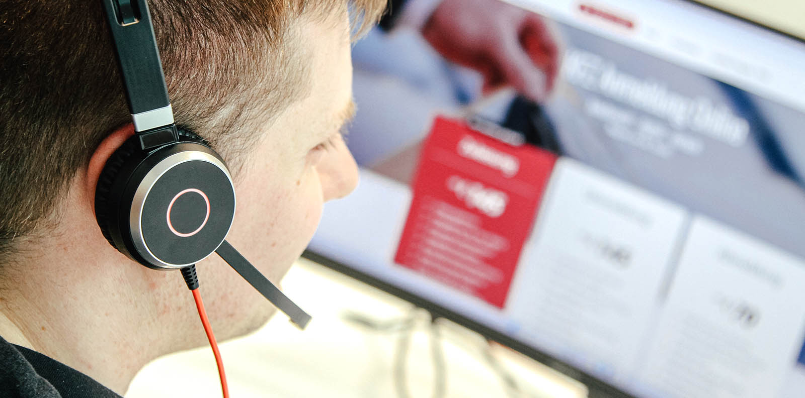 Mann mit Kopfhörer vor Computermonitor